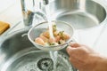 man rinses some white strawberries in a colander Royalty Free Stock Photo