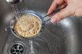 Man rinsing raw quinoa seeds