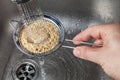 Man rinsing raw quinoa seeds