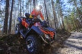 Man rises a quad bike in the forest.