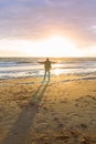 Man rising his arms at the beach at the sea