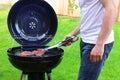 Man roasting beef on BBQ grill