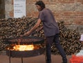 A man roasting chestnuts in a large pan with a fire underneath in an historic hilltop town in Tuscany