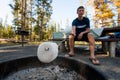 Man Roasting a Marshmallow Over Fire Pit at a Campsite