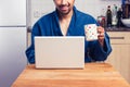 Man in robe checking emails and having coffee Royalty Free Stock Photo