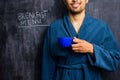 Man in robe next to breakfast menu on blackboard