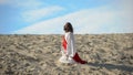 Man in robe repenting for sins, praying to God in desert, pangs of conscience