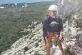 Man rock climber on the top of the cliff and belays a partner