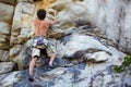 Man, rock climbing and rope hanging on mountain boulder for challenge, risk performance on stone. Male person, exercise Royalty Free Stock Photo