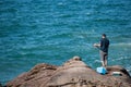 Man rock fishing alone on base of Mount Maunganui