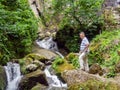 Man on a rock near a stream. Rapids on the river. Shallow river with boulders Clear water stream Royalty Free Stock Photo