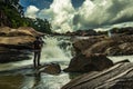 Man at rock watching the beautiful waterfall stream at evening