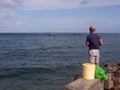 Man rod fishing at the end of the concrete fishing pier