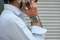 Man with Rolex Submariner watch during a phone call before Emporio Armani fashion show, Milan Fashion Week street