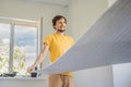 man and a roll of insulating cloth to install a laminate wooden floor