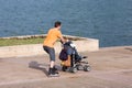 Man on rollerblades pushing a baby stroller