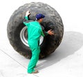 Man rolling huge truck wheel Royalty Free Stock Photo