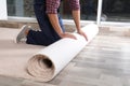 Man rolling out new carpet flooring indoors Royalty Free Stock Photo