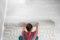 Man rolling out new carpet flooring indoors, top view. Royalty Free Stock Photo