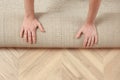 Man rolling out new carpet flooring indoors, top view. Space for text Royalty Free Stock Photo