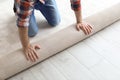 Man rolling out new carpet flooring Royalty Free Stock Photo