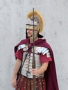 a man in a roman costume and holding a sword at his shoulder