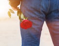 Man with a rose behind his back waiting for love. Romantic date on the beach Royalty Free Stock Photo