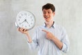 Man with a round big clock in his hands expresses various emotions Royalty Free Stock Photo