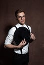 Man in round glasses, suspenders, a white shirt and a hat