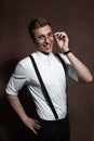 Man in round glasses, suspenders and a white shirt