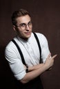 Man in round glasses, suspenders and a white shirt