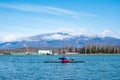 A man rower floats on a kayak rowing oars. background mountain landscape