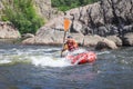 A man rowing inflatable packraft on whitewater of mountain river. Concept: summer extreme water sport, active rest, extreme