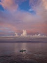 Man rowing a small canoe during sunset at Nusa Lembongan Island