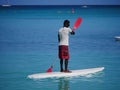 Man rowing surf board in standing position