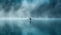 Man rows boat in misty lake surrounded by foggy natural landscape Royalty Free Stock Photo