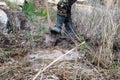 man in rubber boots digs a shovel pit in a swamp. Finding water