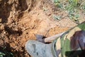 man in rubber boots digs a shovel pit in a swamp. Finding water