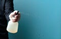 Man in rubber glove sprays disinfectant on a glass, selective focus