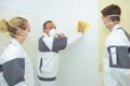 Man rubbing down wall apprentices watching Royalty Free Stock Photo