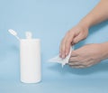 A man rubs his hands with a wet disinfectant wipe on a blue background. The concept of antiseptic wipes against coronovirus and