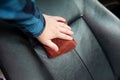 Man rubs the leather seats of auto. Car interior care concept