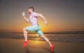 Man runner jogger running. Young guy running along the beach of the sea during an amazing sunset. Royalty Free Stock Photo