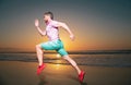 Man runner jogger running. Young guy running along the beach of the sea during an amazing sunset. Royalty Free Stock Photo