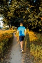 Man runner jogging on an outdoor path during sunset. Healthy lifestyle concept.