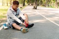 Man runner knee injury and pain while sitting on the road in the park. Male athlete suffering from painful knee with Royalty Free Stock Photo