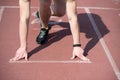 Man runner with muscular hands, legs start on running track