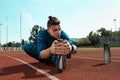 Man runner stretching legs preparing for run training on stadium tracks doing warm-up Royalty Free Stock Photo