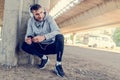 Man runner taking a break after intensive training outdoors, listening music on his mobile smart phone Royalty Free Stock Photo