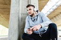 Man runner taking a break after intensive training outdoors, listening music on his mobile smart phone Royalty Free Stock Photo